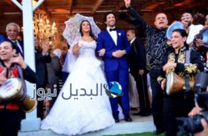 إيمي سمير غانم تمسك بمظلة في زفتها على حسن الرداد